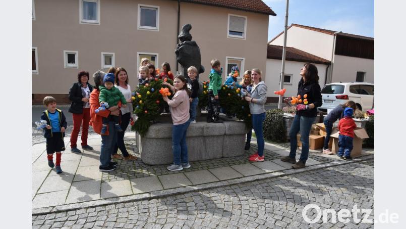 Die Kinder sind mit Freude dabei, den Osterbrunnen zu schmücken. Bild: fz