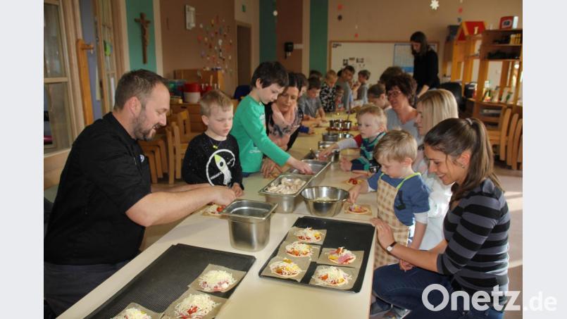 Unter der Anleitung von Kräuterkoch Andreas Meier (vorne links) durften die Kinder ihre Pizzas selbst belegen und natürlich dann essen. Das machte mächtig Spaß. Bild: frd
