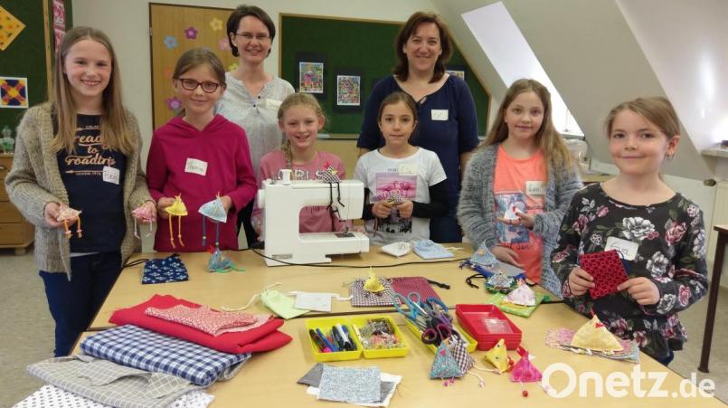 VHS-Kindernähkurs: Das Foto zeigt die stolzen jungen Teilnehmerinnen mit den selbst genähten Gegenständen, die sie mit nach Hause nehmen konnten, sowie die Kursleiterinnen Irene Weber (Dritte von links) und Evi Kürzinger (Sechste von links). Bild: mül