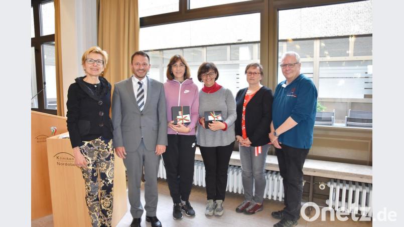 Weidens Bürgermeister Jens Meyer übergibt den beiden italienischen Betreuungslehrerinnen Antonella Gentili und Stefania Minozzi beim Empfang in der Kantine des Weidener Klinikums ein Gastgeschenk. Bild: pmen