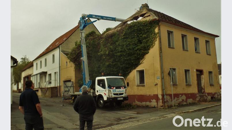 Der Abriss beginnt. Von oben nach unten wird das alte Beer-Walbrunn-Geburtshaus entblättert. Die Kunstschiefer-Dachdeckung muss als Sondermüll behandelt werden und bei der imposanten Efeupflanze ist entblättern wörtlich zu nehmen. Karlheinz Meier, stellvertretender Vorsitzender des Kunst- und Kulturvereins Anton Beer- Walbrunn und ein großer Befürworter des Erhalts des Gebäudes (rechts), beobachtet das Geschehen. Bild: jml