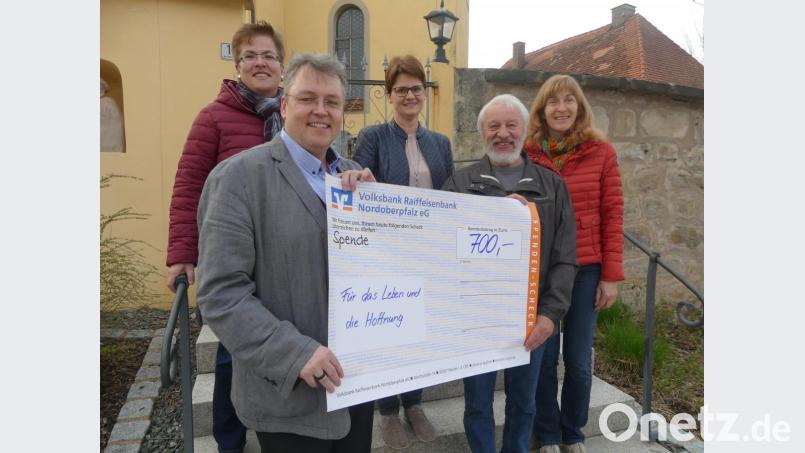 Gertrud Hofmann (rechts) übergibt zusammen mit den Mitgliedern des Pfarrgemeinderats und Pfarrer Pater Adrian Kugler (vorne, links) an Hans Karl den Spendenerlös aus der Filmvorführung. Bild: rn