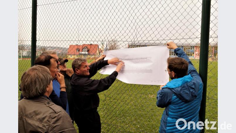 Architekt Georg Binner (zweiter von rechts) erläutert auf dem Plan den Zugang zum Schulsportplatz. Bild: arw