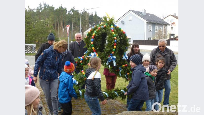 Der Osterbrunnen ist fertig. Die Helfer haben ihn mit 800 bunten Eiern und Girlanden geschmückt. Bild: bk
