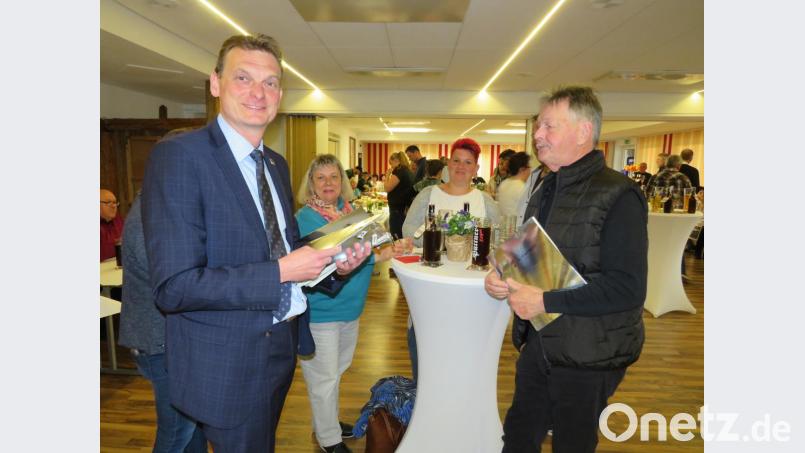 Mit einer Informationsmappe begrüßte Bürgermeister Ernst Schicketanz (links) die neuen Einwohner in der Gemeinde. Bild: adj