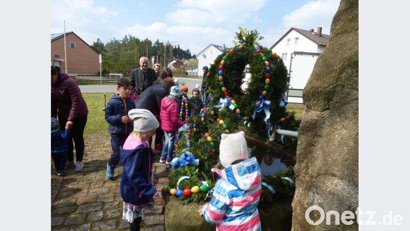Der Osterbrunnen ist fertig. Die Helfer haben ihn mit 800 bunten Eiern und Girlanden geschmückt. Bild: bk