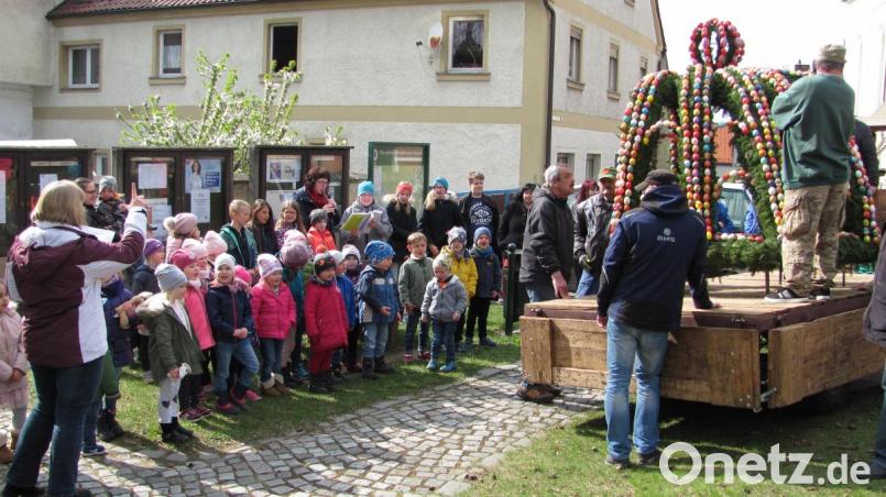 Während die Männer der Kolpingsfamilie den geschmückten Brunnenaufsatz auf den Brunnen am Marktplatz hoben, sang der Kinderchor Pfiffikusbande unter Leitung von Susanne Hausmann. Bild: sei