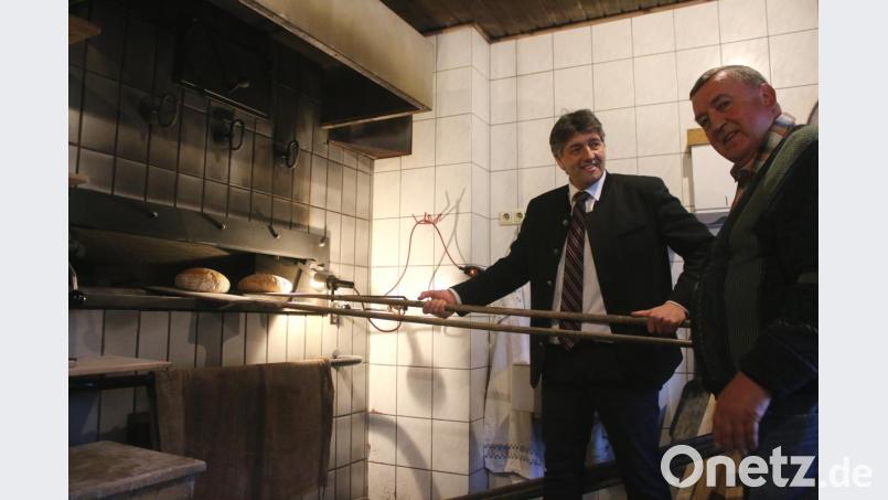 Die beiden Vorsitzenden des neuen "Brot- und Backverein Stadtmühle" Edgar Knobloch (links) und Hans Speckner holen frischgebackenes Brot aus dem Holzofen. Bild: sne
