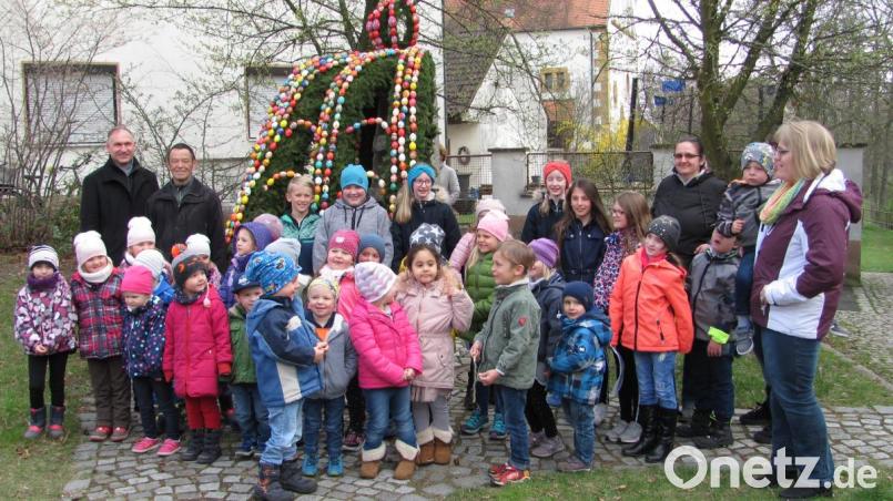 Viel Beifall der Zuschauer belohnte den Kinderchor Pfiffikusbande die beim Aufstellen des Osterbrunnens mit erfrischenden Liedern die Zuschauer erfreute mit Leiterin Susanne Hausmann (rechts) Bürgermeister Richard Kammerer (hinten links) bedankte sich bei Kolpings-Vorsitzendem Georg SChlehuber (hinen 2. v. links) für das jahrzehntelange Engement der Kolpingsfamilie und beim Kinderchor. Bild: sei