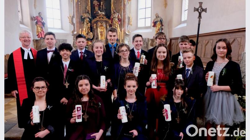 Die evangelische Kirchengemeinde St. Johannes Baptista steht ganz im Zeichen der Konfirmation. Pfarrer Wilfried Römischer (stehend, links) segnet am Altar acht junge Männer und acht junge Frauen. Bild: le