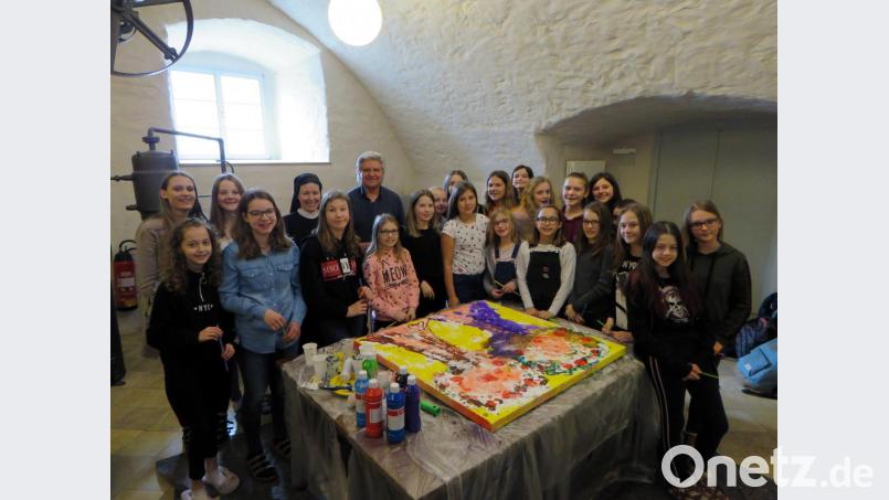 Stolz zeigt die Klasse 6a, was im Benefizprojekt entstanden ist. Künstler Tom Brankovic und die stellvertretende Schulleiterin, Schwester Raphaela, sind sehr zufrieden. Bild: ubb