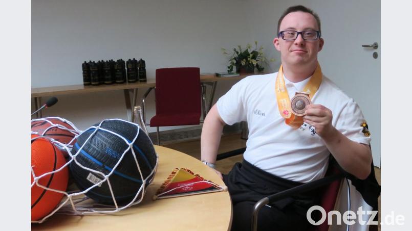 Stolz zeigt Michael Freisinger seine Bronzemedaille her, die er mit seiner Mannschaft bei den Special-Games in Abu Dhabi gewonnen hat. Vom Oberbürgermeister bekam er neue Basketbälle. Bild: Hirsch