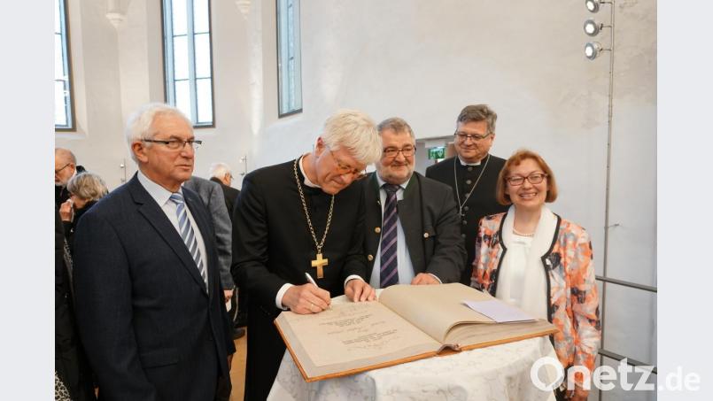 Der evangelische Landesbischof Heinrich Bedford-Strohm (ab Zweiter von links) trug sich im Beisein von Bürgermeister Armin Schärtl, Dekan Karlhermann Schötz und Pfarrerin Irene Friedrich ins Goldene Buch ein. Bild: Christopher Dotzler