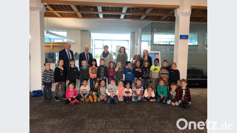 Richard Götz und Stefan Schedl von der Raiffeisenbank führen die Vorschulkinder der städtischen Kindertagesstätte durch das Geldinstitut. Bild: rn