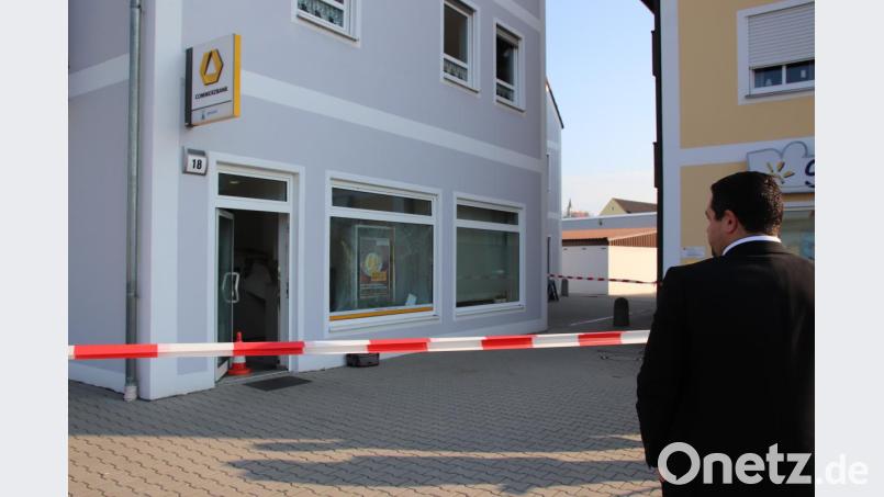 Commerzbank-Filialleiter Bastian Wild besieht sich von der Polizeiabsperrung aus den Schaden an dem SB-Center in Schwarzenfeld, den die Sprengung des Geldautomaten im Innern des Gebäudes angerichtet hat. Bild: Thomas Dobler