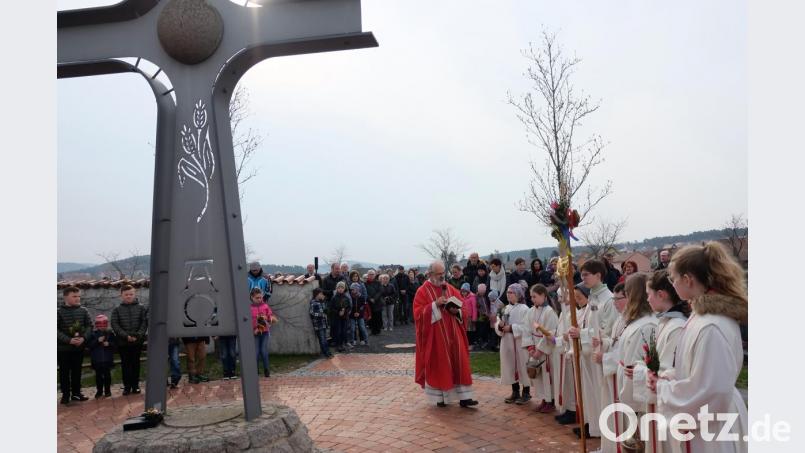 Am Palmsonntag versammelten sich die Gläubigen der Pfarrei Stulln um das Friedhofskreuz. Pfarrer Heinrich Rosner segnete Palmzweige und Palmbuschen. Bild: ohr