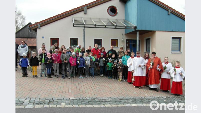 Die Teilnehmer an der Palmprozession stellen sich vor dem Kindergarten St. Anna auf. Bild: hl