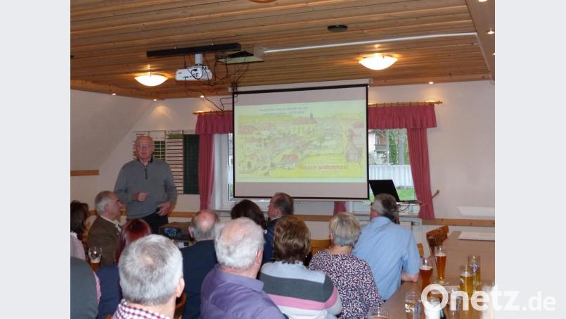 Johann Zeiler beim Vortrag vor eine Skizze/Bild vom alten Neudorf. Bild: hme