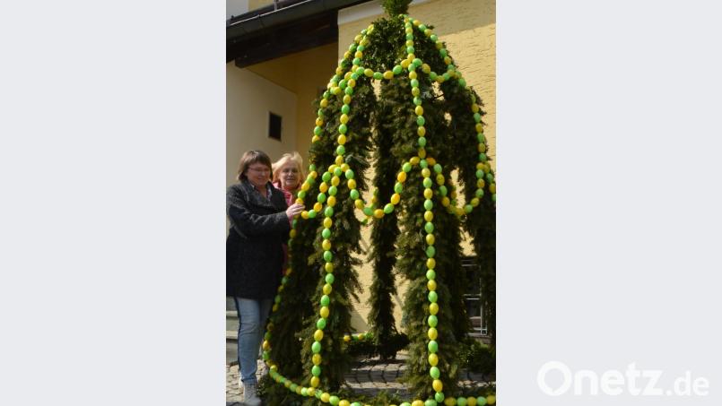 Frauenbundmitglieder legen schnell noch die letzten Handgriffe an, bevor die Krone auf den Brunnen gehoben wird. Bild: dob
