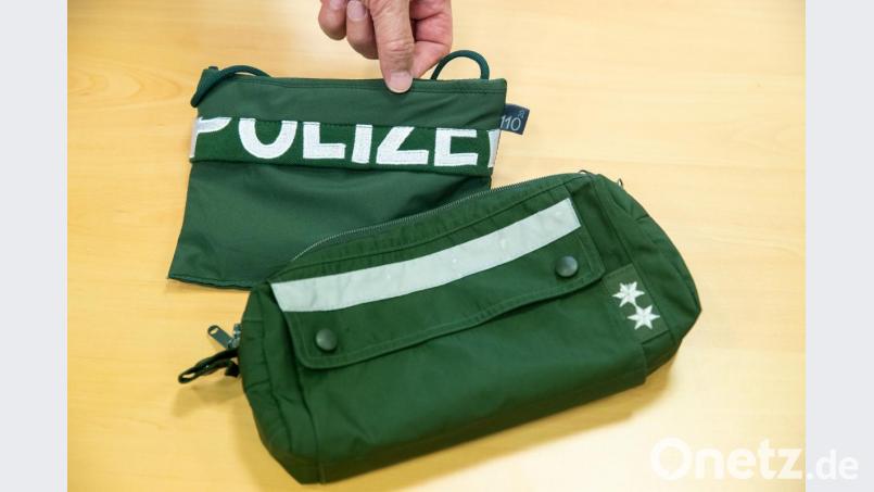 Ein Brustbeutel und eine Fahrrad-Lenkertasche gefertigt aus Stoffen alter Polizei-Uniformen liegen auf einem Tisch. Bild: Daniel Karmann