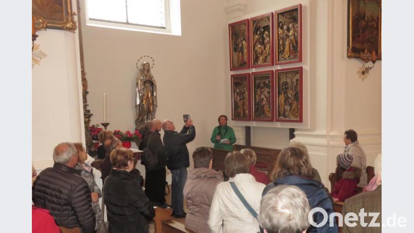 Gästeführerin Elisabeth Hammer (Mitte) brachte den 33 Interessierten die Besonderheiten der Stadtpfarrkirche St. Ägidius nahe, zum Beispiel die Relieftafeln des einstigen Flügelaltars aus der Dürerschule. Bild: rha
