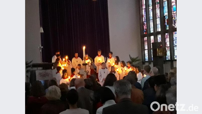 Pfarrer Thomas Stohldreier beim &quot;Exsultet&quot; vor der Osterkerze, dem Lobgesang auf die Osternacht. Die Ministranten formieren sich dafür zu einem Omega. Bild: ise
