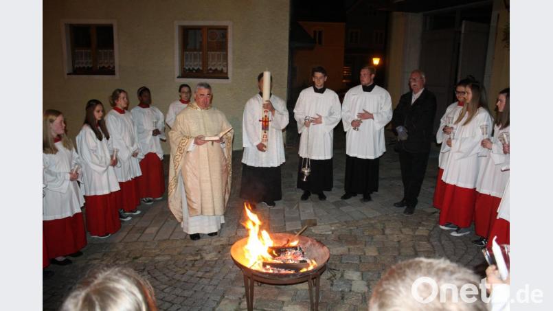 An der eisernen Feuerschale vor dem Kirchenportal wurde im Kreise der Ministrantenschar die Osterkerze entzündet. Bild: lg