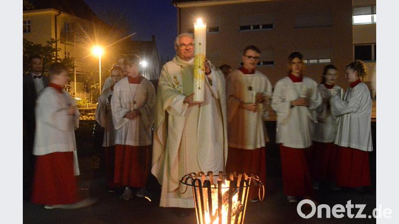 Stadtpfarrer Gerhard Pausch entzündet vor der Herz Jesu Kirche die Osterkerze. Bild: Kunz