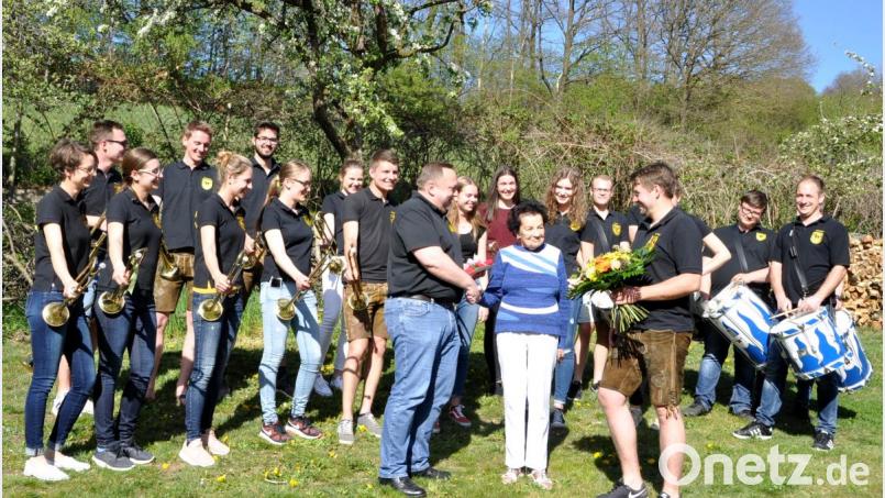 Fanfarenspieler und Trommler der Kolping-Fanfarengruppe ist die Überraschung gelungen. Vorsitzender Josef Schneider (rechts) und Leiter Rainer Dobmeier (links) bedanken sich mit einem Blumenstrauß und einem Gutschein bei Uschi Haubmann (Mitte) für ihre vielen Dienste in fast 30 Jahren. Bild: es