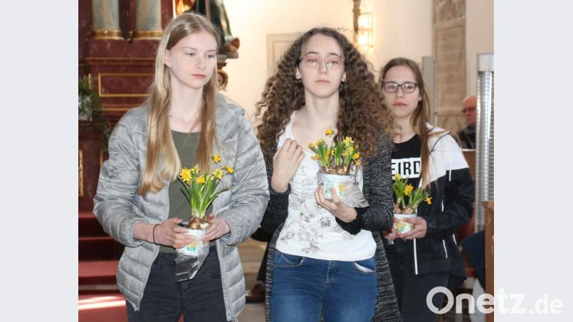 Paula Wolf und die Konfirmanden bringen Osterglocken für den Ostergarten. Sie sind ein Symbol für die Auferstehung und das Leben. Bild: rpp