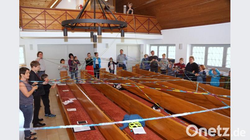Die Kirchenbesucher werfen sich gegenseitig ein Wollknäuel zu. Das dadurch entstehende Netz symbolisiert, wie sich die Botschaft von der Auferstehung Christi von einem zum anderen verbreitet hat. Bild: bkr