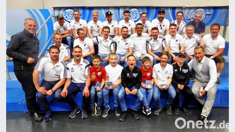 „Blickpunkt Sport“-Moderator Markus Othmer (vorne rechts) und Ex-Club-Trainer Michael Köllner (Mitte) gesellen sich nach der Live-Sendung zum frisch gebackenen Kreisligaaufsteiger ASV Haidenaab-Göppmannsbühl um Vorsitzenden Stephan Veigl sowie Jugend- und Schülerabteilungsleiter Markus Schäffner (vorne, sitzend von links). Bild: hai