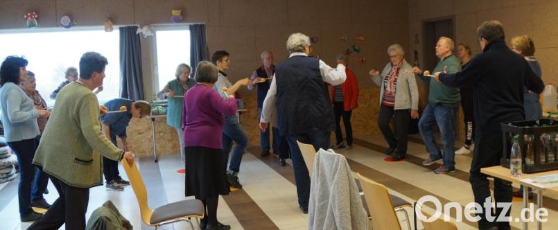 Übungsleiter Michael Welnhofer (vierter von rechts) führte mit den Teilnehmern einfache Bewegungsübungen mit Haushaltsgeräten durch. Bild: weu