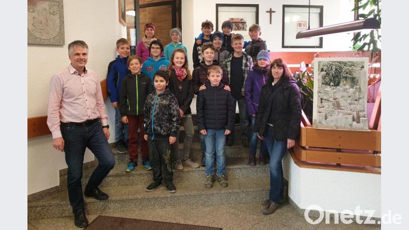 Bürgermeister Thomas Meiler (links) mit Schülern der Grundschule der dritten und vierten Klasse und der Klassenlehrerin Gudrun Lehner (rechts) im Foyer des Rathauses. Bild: cro