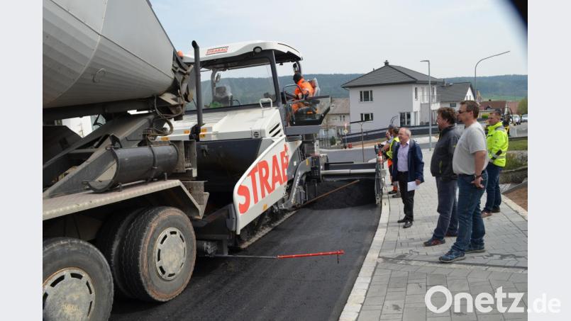 Sandro Spickenreuther, Gunther König, Bürgermeister Gerhard Scharl (vorne, von rechts) und Markus Schieder beobachten, mit welcher Präzision der Asphaltfertiger die Feinschicht aufzieht. Bild: fz