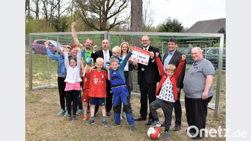 Sparkassen-Vorstandsvorsitzender Josef Pflaum (hinten, Vierter von links) überreicht den symbolischen Scheck in Höhe von 1.500 Euro für den KAB-Spielplatz Hütten. Bild: rgr