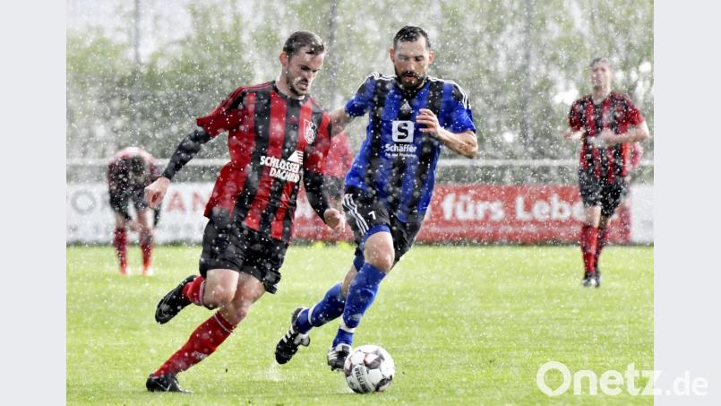 Ein Laufduell im strömenden Gewitterregen zwischen dem Paulsdorfer Stürmer Tobias Scherm (links vorne) und dem Raigeringer Mittelfeldspieler Michael Muck. Bild: Hubert Ziegler