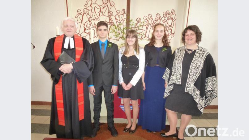 Pfarrer Martin Valeske freut sich mit den Konfirmanden (von links) Jonas Gießübl, Tina Grill und Marlene Kellermann. Kirchenvorsteherin Martina Kellermann gratuliert. Bild: bk