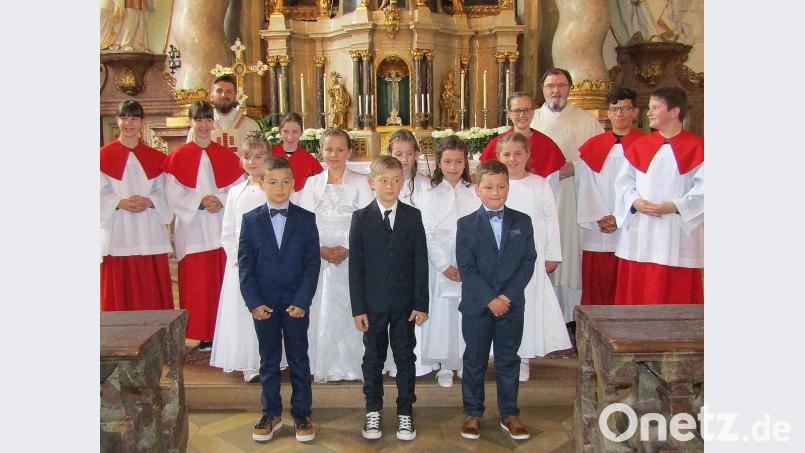 Pater Tomasz Rostek (hinten links) und Diakon Franz-Josef Reck (hinten rechts) mit den Kommunionkindern (mittlere Reihe, von links) Sophia Worlitz, Marlene Gsell, Paula Strobl, Laura Meinl, Leonie Lindner sowie (vordere Reihe, von links) Julius Förster, Noah Kohl und Leo Kroher. Bild: sck