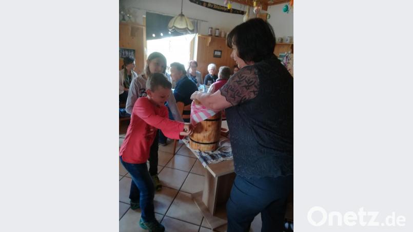 Beim Ausbutternachmittag drehen die Kinder fleißig am Butterfass. Bild: ak