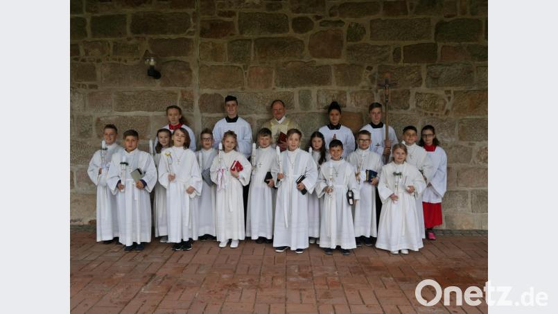 Pfarrer Heribert Stretz (hinten, Mitte) und seine Ministranten feiern mit den Kommunionkindern (mittlere Reihe, von links) Hannes Huslig, Katharina Übelmesser, Felix Trastl, Vincent Vollath, Leni Sertl, Maximilian Köster und Franz Dimper sowie (vordere Reihe, von links) Noah Kirchberger, Florian Neuber, Sophia Schmidt, Ivan Ponnath, Marco Herrmann und Linda Wagner ihre Kommunion. Bild: exb