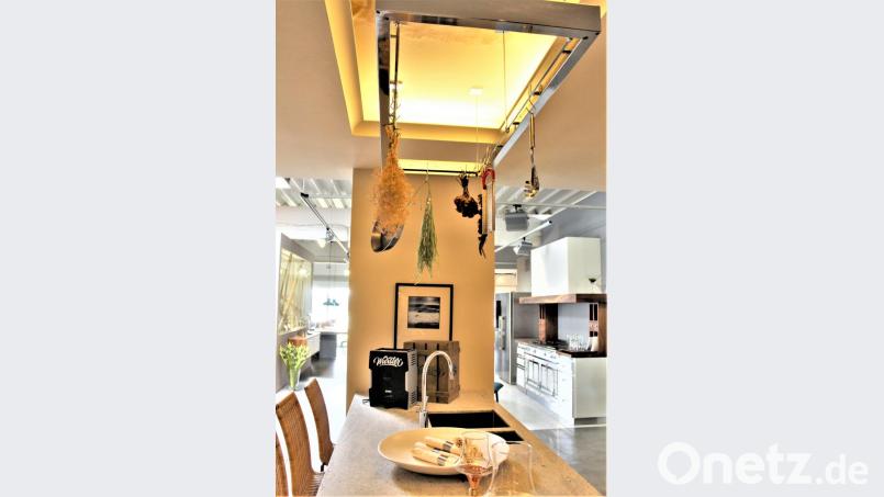 Alles in einem, Raumhöhe optimal genutzt: Theke und Arbeitsfläche unten, von oben wie im Landeanflug das passende Kochwerkzeug. Bild: mvs