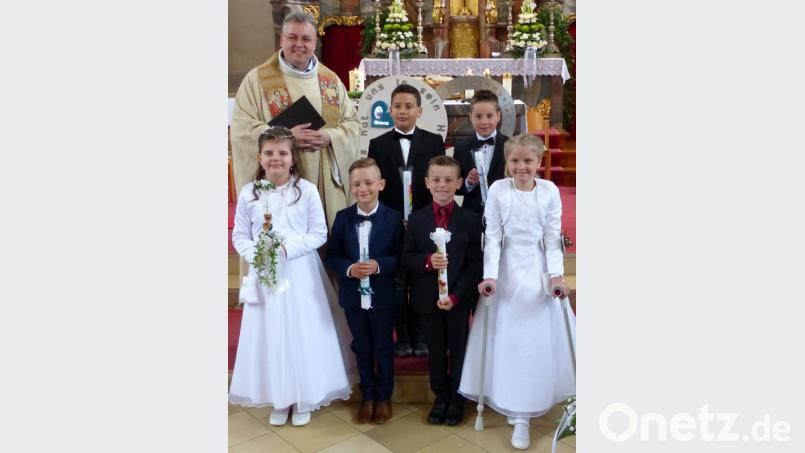 Pater Adrian Kugler mit den Erstkommunionkindern nach dem Festgottesdienst in der Pfarrkirche St. Luzia. Bild: lgc