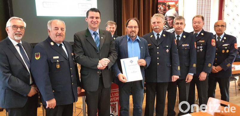 Die Feuerwehrführung und die Ehrengäste bedankten sich bei Sachbearbeiter Thomas Holzwarth (mit Urkunde) und verliehen ihm das Ehrenzeichen des Kreisfeuerwehrverbandes. Bild: Hirsch