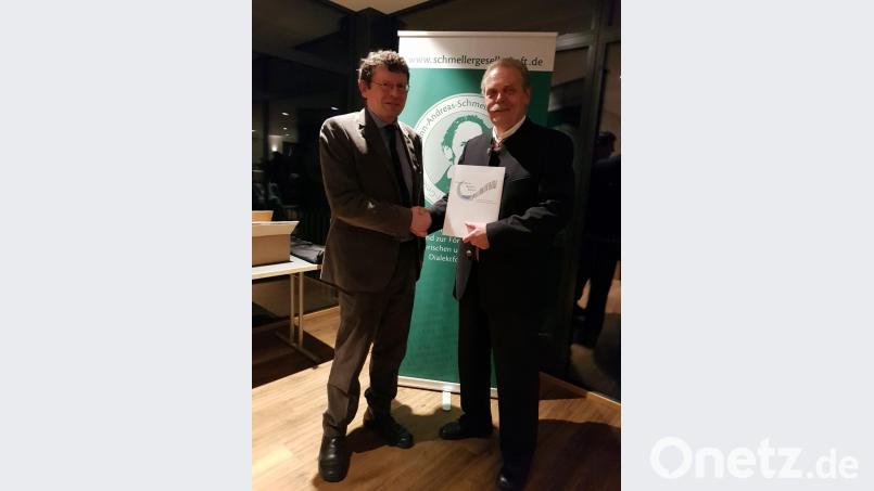 Ludwig Schießl (rechts) gratuliert Christian Ferstl mit einem Buchgeschenk zum 40-jährigen Jubiläum der Johann-Andreas-Schmeller-Gesellschaft. Bild: slu