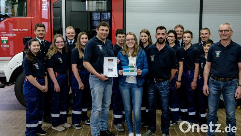 Die glücklichere Gewinnerin der Verlosungsaktion Franziska Bierler aus Georgenberg (Bildmitte) nimmt bei der Jugendfeuerwehr Teunz ihren Gutschein in Empfang. Bild: tkr