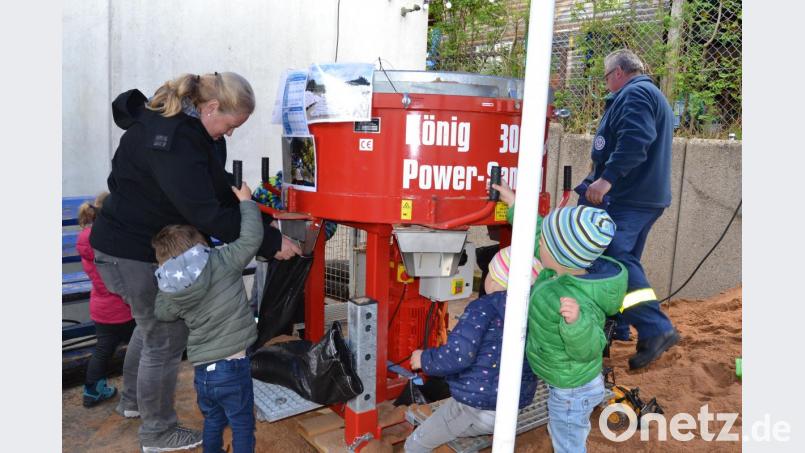Sie dürfen auch mal ran: Kinder an der Sandsack-Befüllmaschine des THW. Bild: hcz