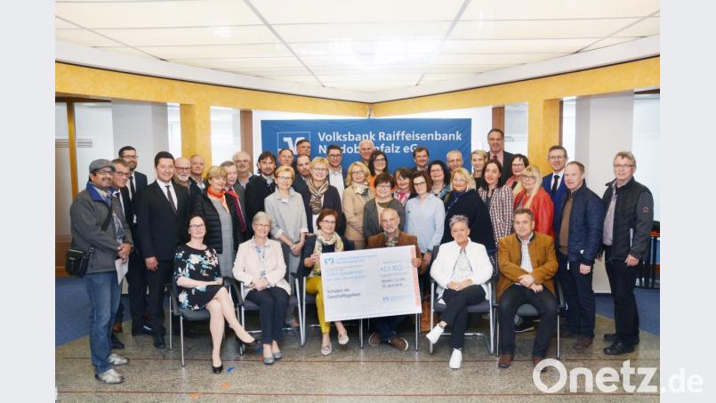 Christian Weigert (Dritter von rechts) übergibt
eine Spende in Höhe von 27.500 Euro der Volksbank Raiffeisenbank an Vertreter von 38 Schulen aus Weiden und dem Landkreis. Weitere 28 Bildungseinrichtungen erhielten Spenden in Tirschenreuth und Eschenbach. Bild: Gabi Schönberger
