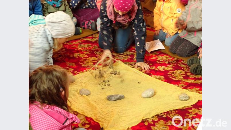 Als Sinnbild für die öde Wüste legten die Kinder Steine und Gestrüpp auf das gelbe Tuch. Bild: jzk