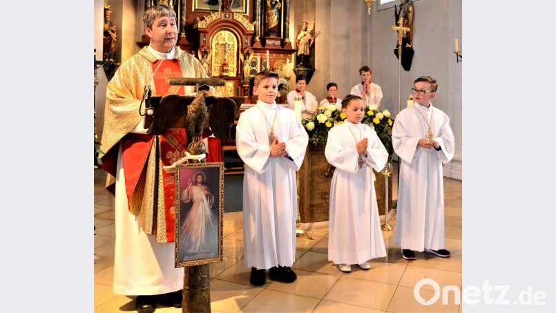 Pfarrer Adam Nieciecki mit den Kommunionkindern. Bild: fz